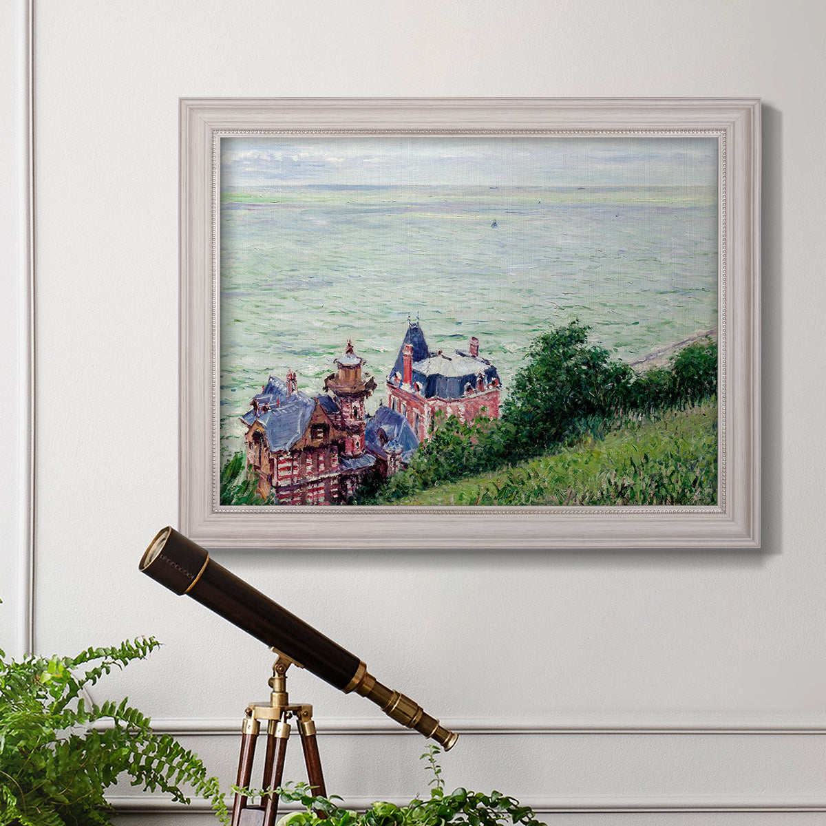 Impressionist coastal villas landscape by Gustave Caillebotte in an ornate weathered white frame displayed in a light-toned interior setting.