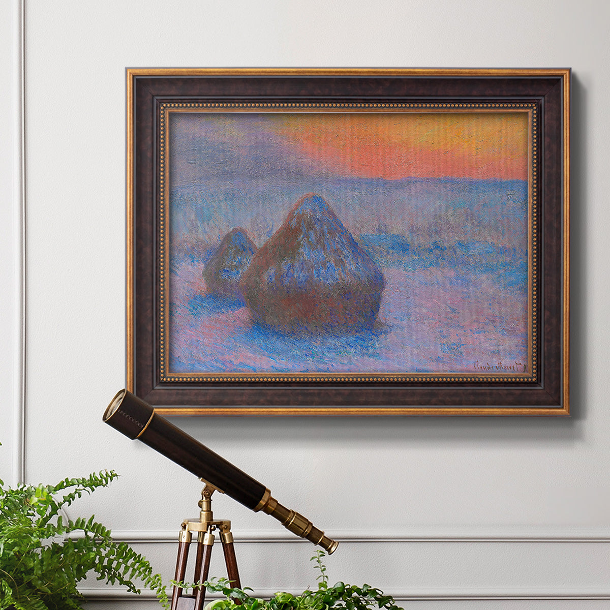 Impressionist haystack scene at sunset by Claude Monet in an ornate bronzed mahogany wood frame displayed in a light-toned interior setting.