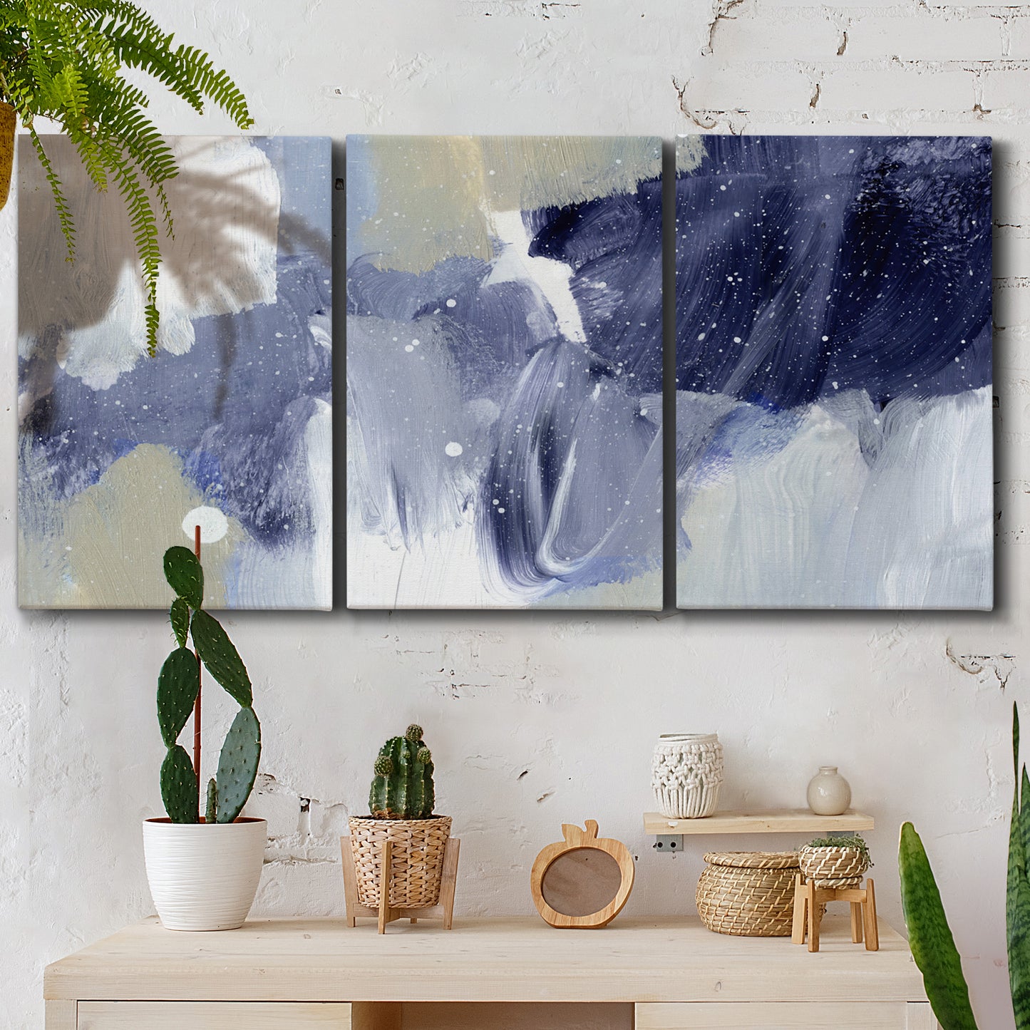 Three-panel canvas wall art featuring abstract sky break composition, displayed in a boho-chic entryway above a console table.