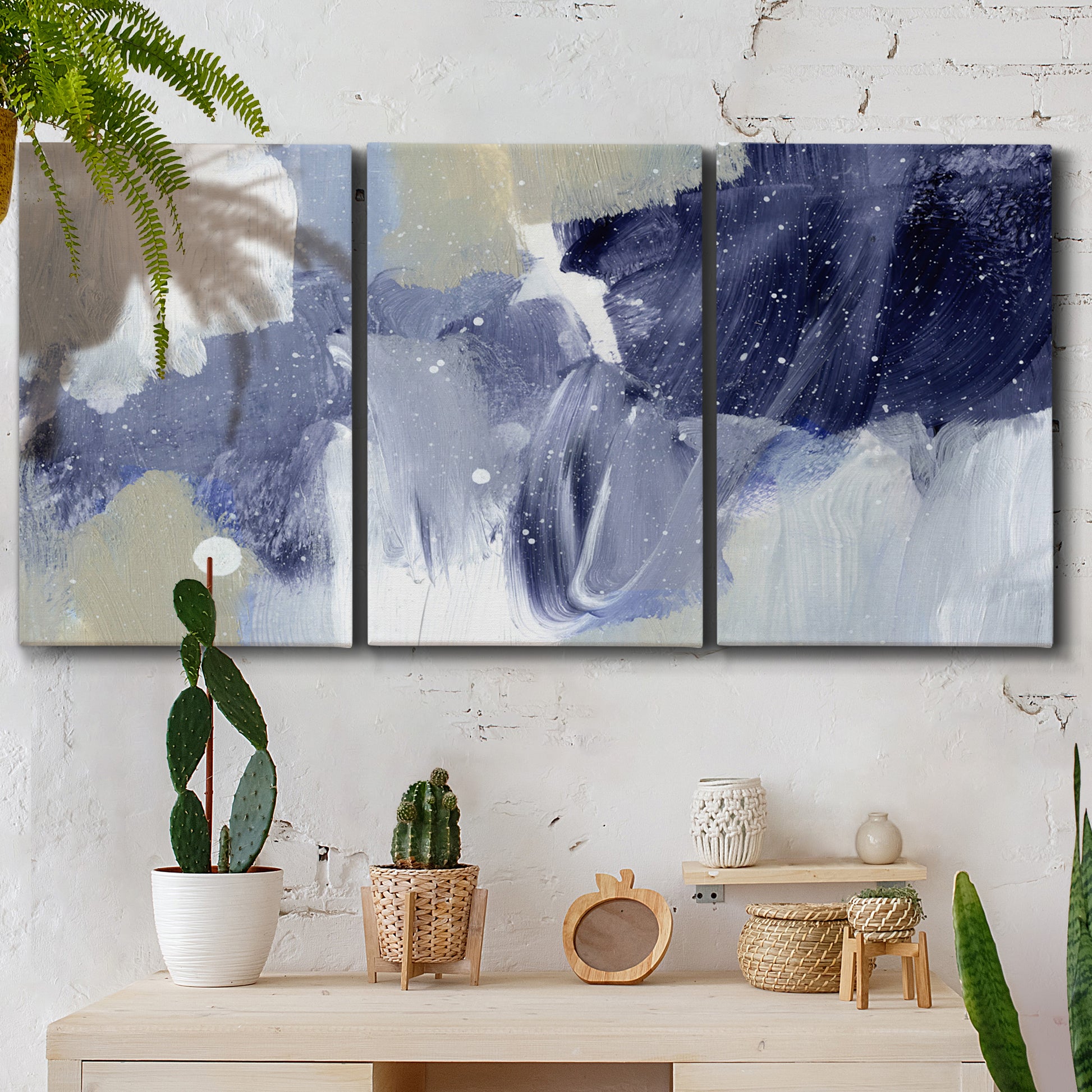 Three-panel canvas wall art featuring abstract sky break composition, displayed in a boho-chic entryway above a console table.