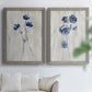 Set of two gray barnwood framed canvas prints depicting indigo blossoms, thin stems, and softly distressed gray backgrounds arranged across two complementary compositions above a sofa in a bright living space.