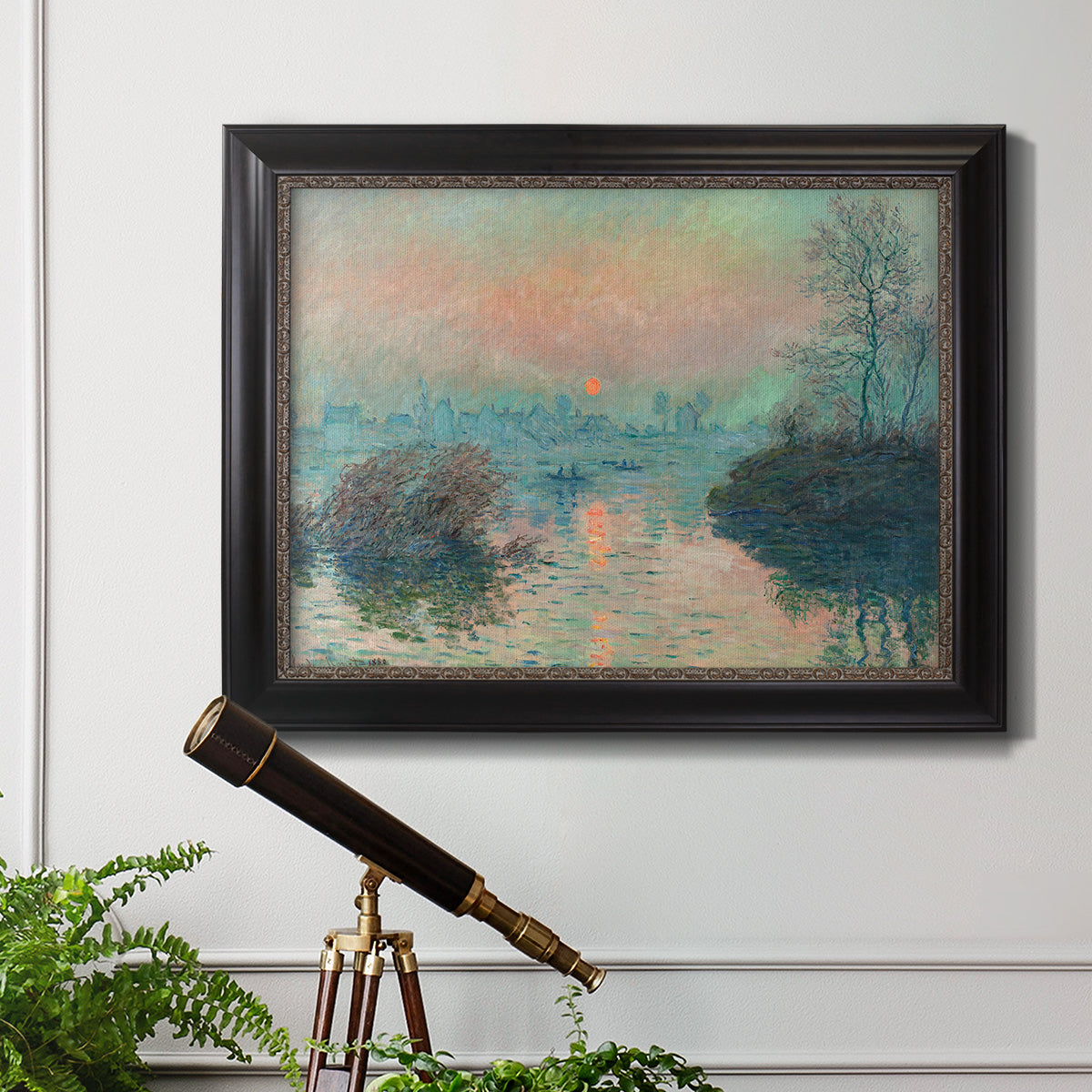 Impressionist winter river sunset scene by Claude Monet in an ornate black frame with gilded inner detail displayed in a light-toned interior setting.