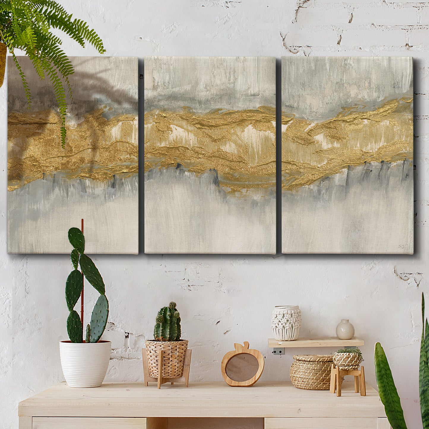 Three-panel canvas wall art featuring flowing abstract golden tones, displayed in a boho-chic entryway above a console table.