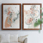 Set of two maple barnwood framed canvas prints depicting scribbled petals, translucent washes, and drifting stems arranged across two complementary compositions above a sofa in a bright living space.