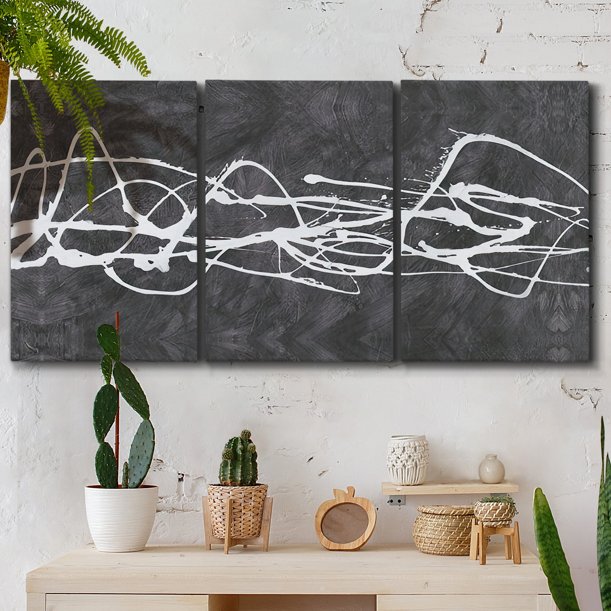 Three-panel canvas wall art featuring minimal abstract frequency lines, displayed in a boho-chic entryway above a console table.