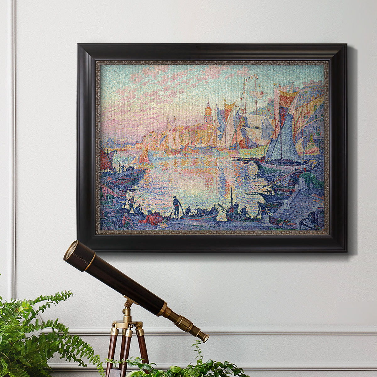 Impressionist Mediterranean harbor painting by Paul Signac in an ornate black frame with gilded inner detail displayed in a light-toned interior setting.