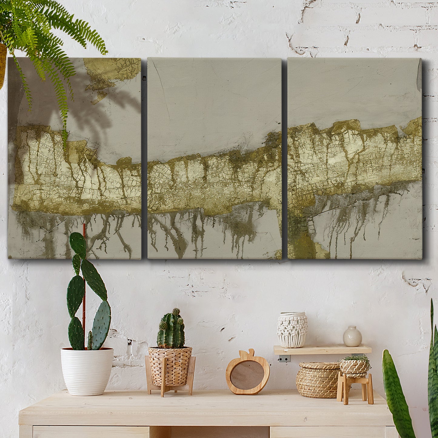 Three-panel canvas wall art featuring gold accented abstract ravine, displayed in a boho-chic entryway above a console table.