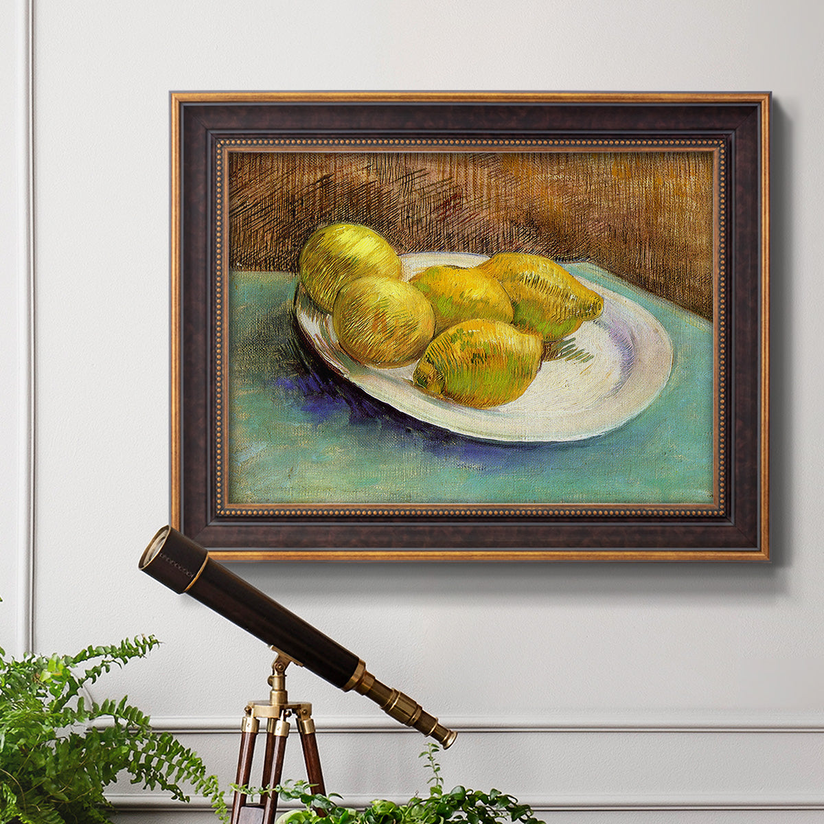 Impressionist still life with lemons by Vincent van Gogh in an ornate bronzed mahogany wood frame displayed in a light-toned interior setting.