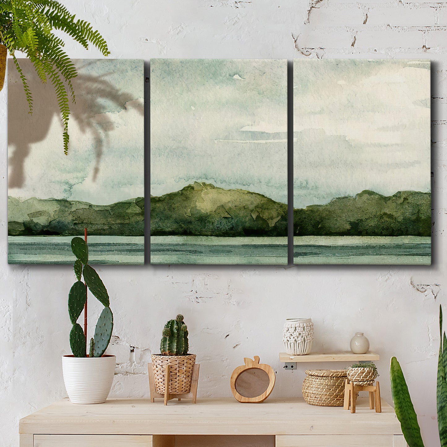 Three-panel canvas wall art featuring riverbank watercolor landscape, displayed in a boho-chic entryway above a console table.
