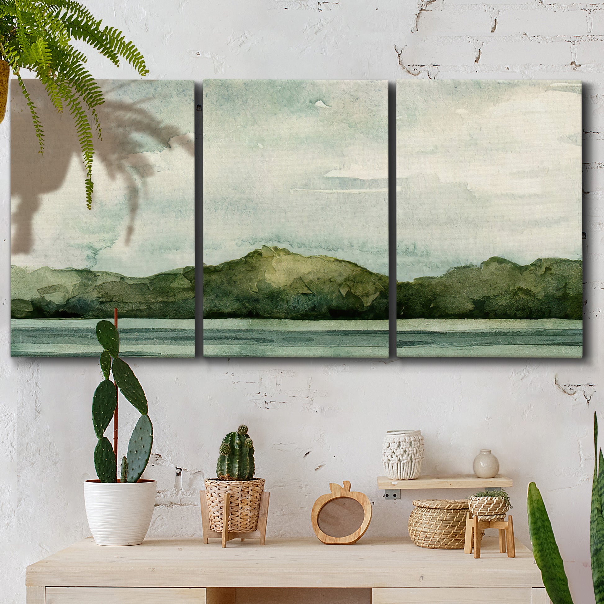 Three-panel canvas wall art featuring riverbank watercolor landscape, displayed in a boho-chic entryway above a console table.