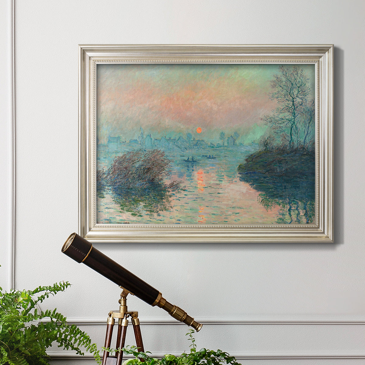 Impressionist winter river sunset scene by Claude Monet in an ornate champagne frame displayed in a light-toned interior setting.