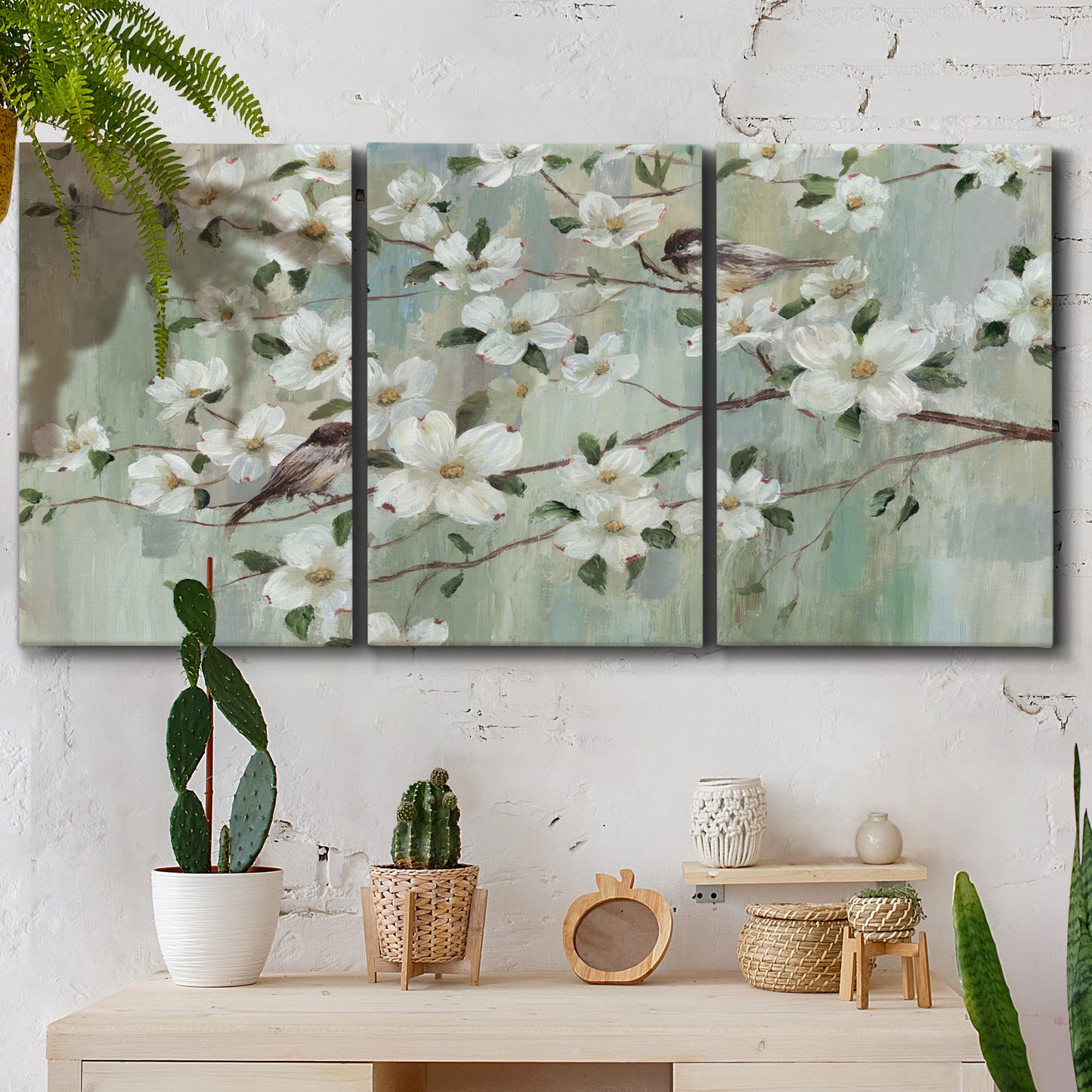 Three-panel canvas wall art featuring delicate spring blossoms with birds, displayed in a boho-chic entryway above a console table.
