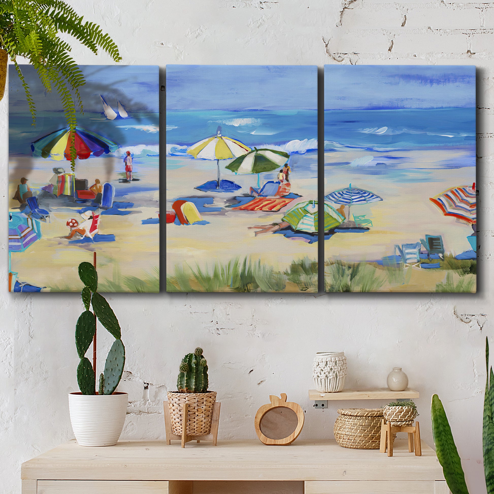 Three-panel canvas wall art featuring sunny coastal beachscape with horizon, displayed in a boho-chic entryway above a console table.