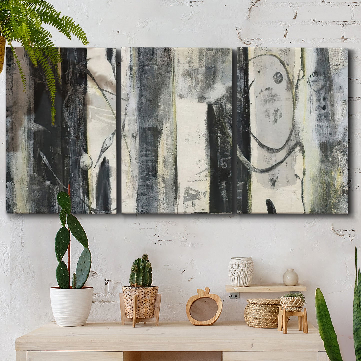 Three-panel canvas wall art featuring vertical abstract tree forms, displayed in a boho-chic entryway above a console table.