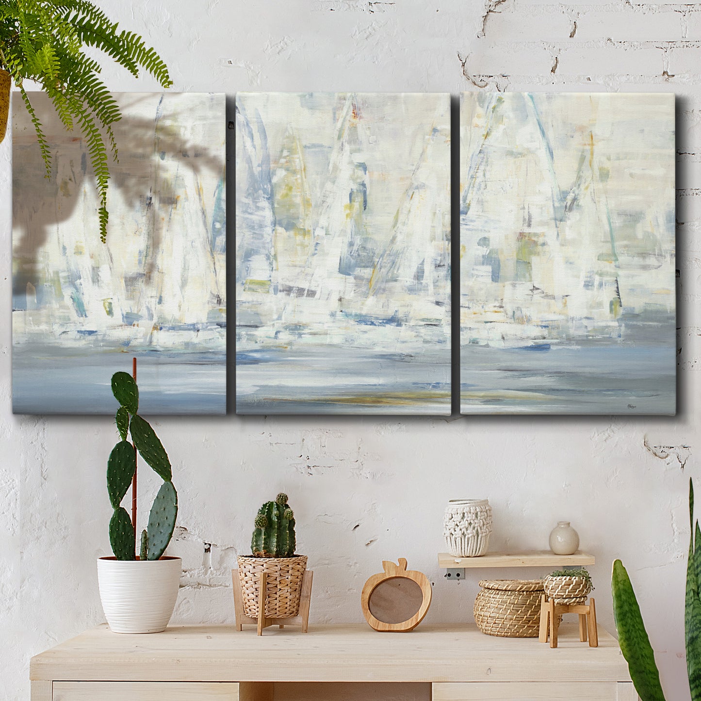 Three-panel canvas wall art featuring impressionist regatta scene with sailboats, displayed in a boho-chic entryway above a console table.