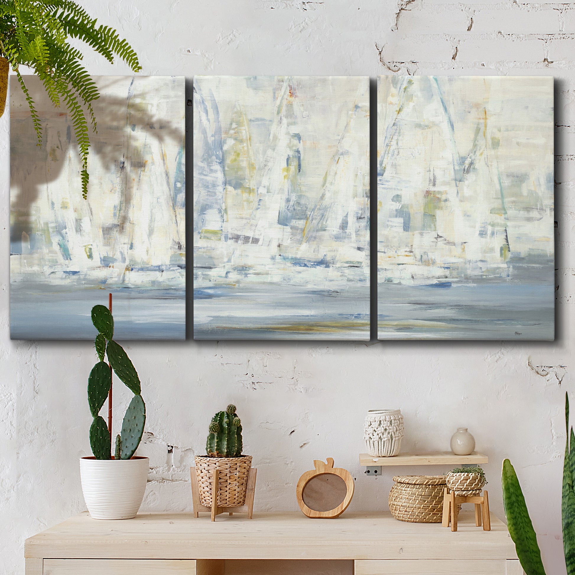 Three-panel canvas wall art featuring impressionist regatta scene with sailboats, displayed in a boho-chic entryway above a console table.