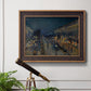 Impressionist nighttime Paris street scene by Camille Pissarro in an ornate bronzed mahogany wood frame displayed in a light-toned interior setting.