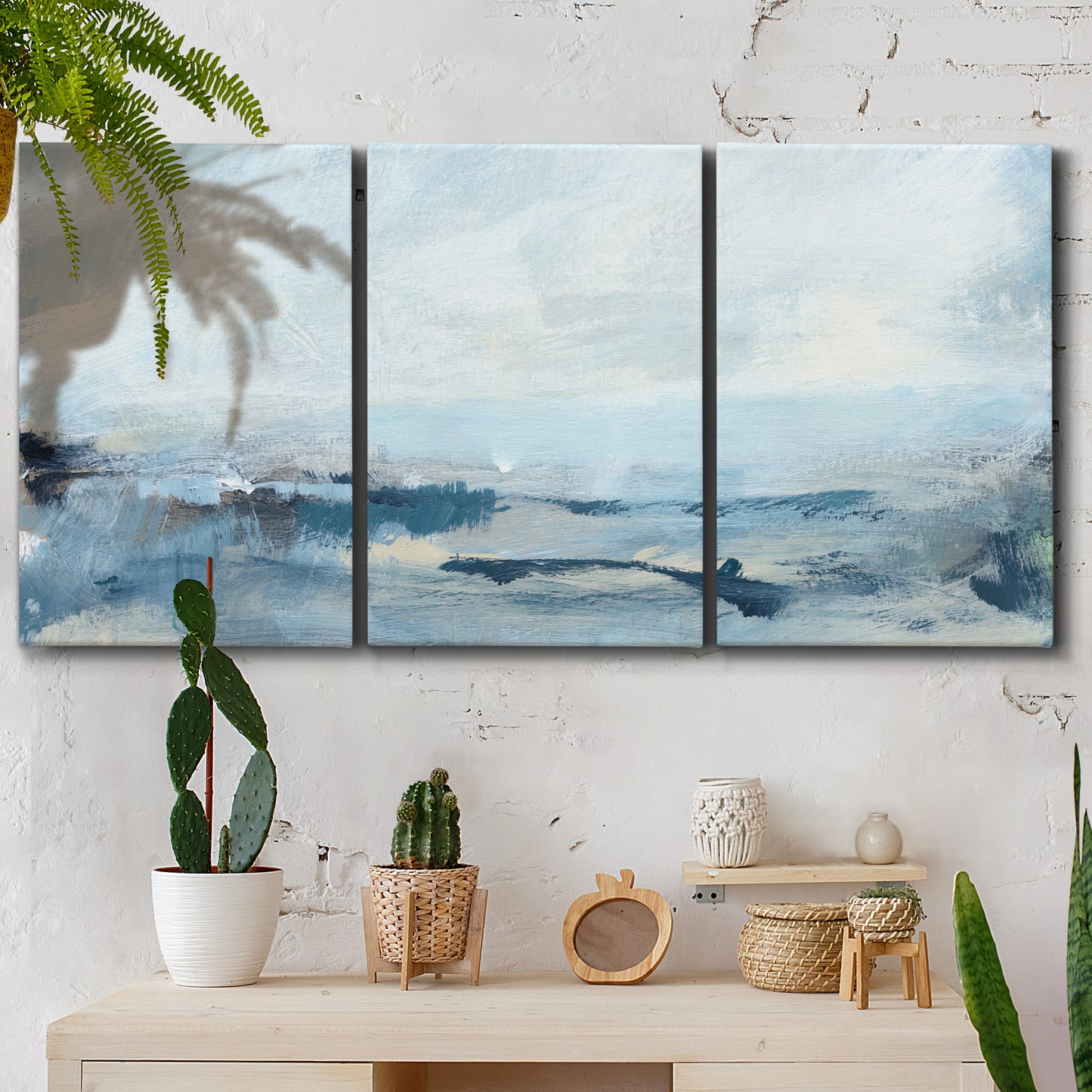 Three-panel canvas wall art featuring abstract sailboats on water, displayed in a boho-chic entryway above a console table.