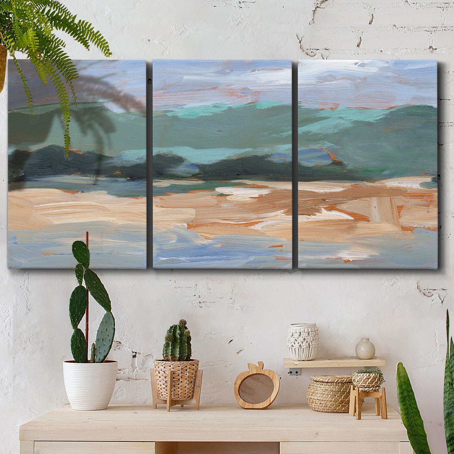 Three-panel canvas wall art featuring abstract landscape composition study, displayed in a boho-chic entryway above a console table.