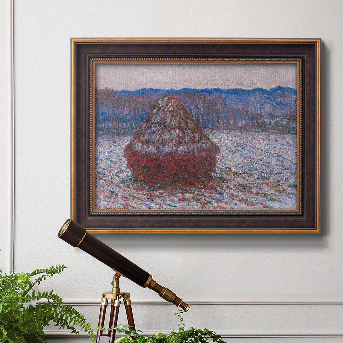 Impressionist single haystack landscape by Claude Monet in an ornate bronzed mahogany wood frame displayed in a light-toned interior setting.