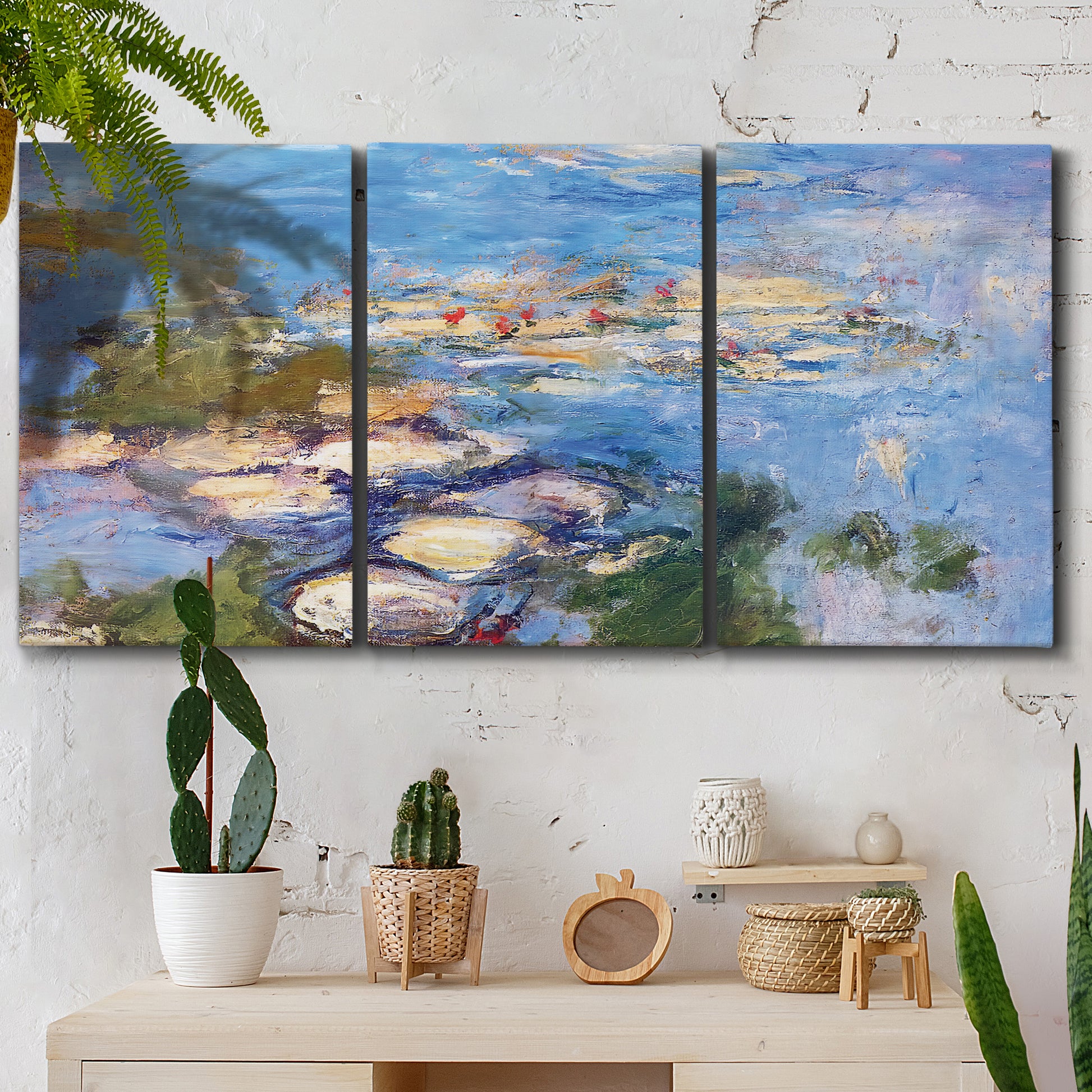 Three-panel canvas wall art featuring water lilies in blue and gold, displayed in a boho-chic entryway above a console table.