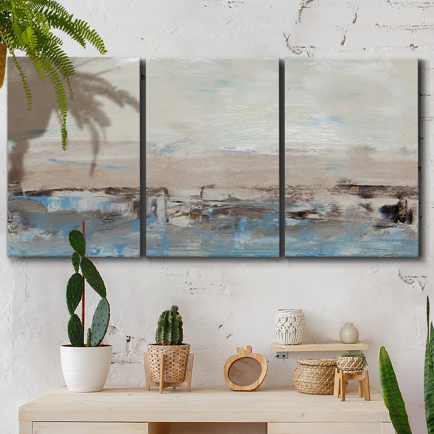 Three-panel canvas wall art featuring abstract bridge landscape in cyan, displayed in a boho-chic entryway above a console table.