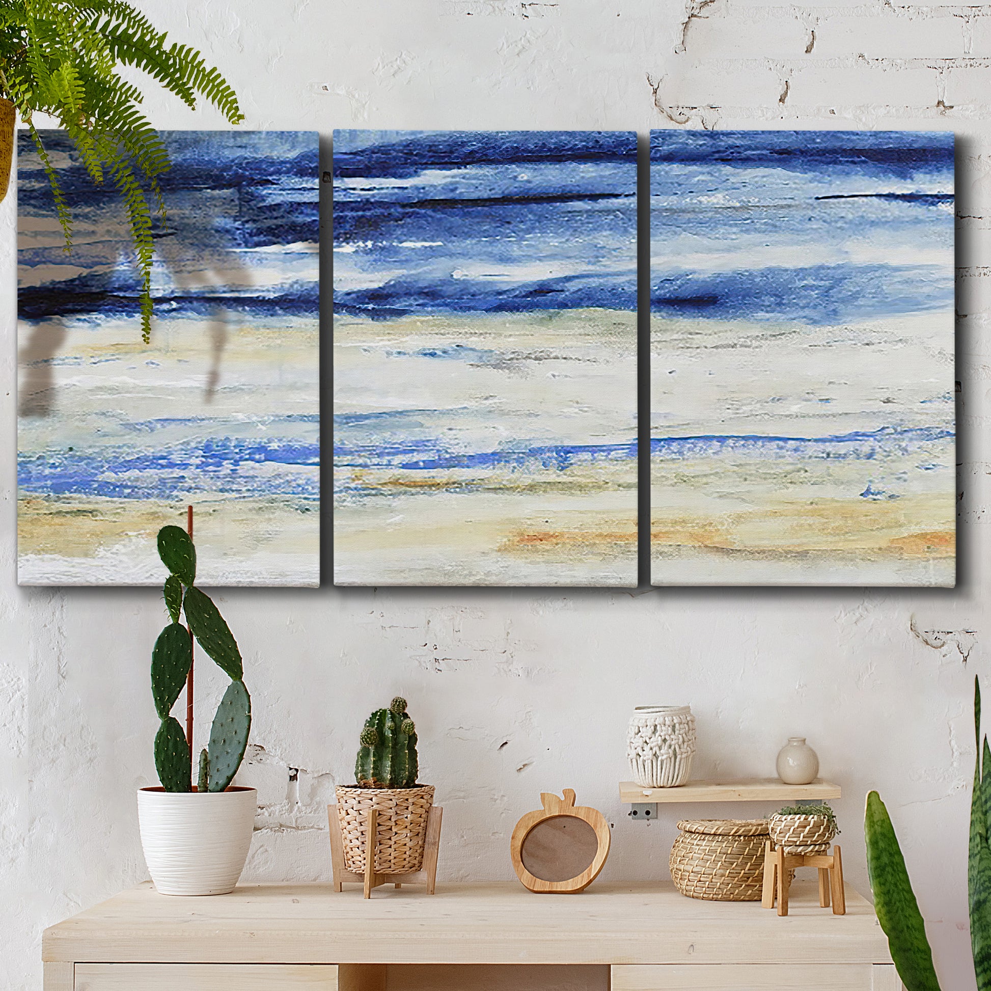 Three-panel canvas wall art featuring turbulent abstract ocean wave motion, displayed in a boho-chic entryway above a console table.