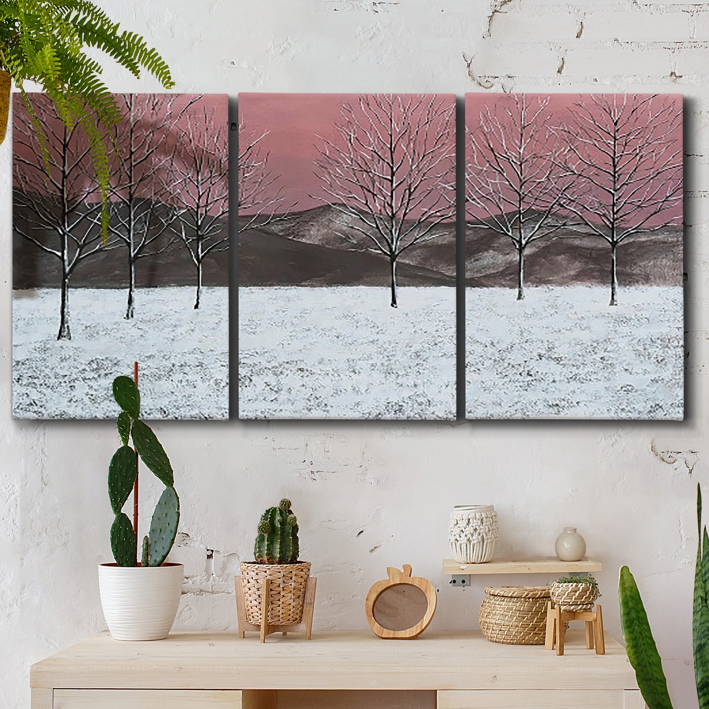 Three-panel canvas wall art featuring winter sunset snowfall landscape, displayed in a boho-chic entryway above a console table.