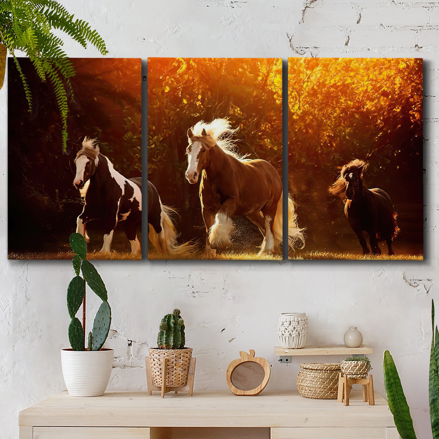 Three-panel canvas wall art featuring running horses across open field, displayed in a boho-chic entryway above a console table.