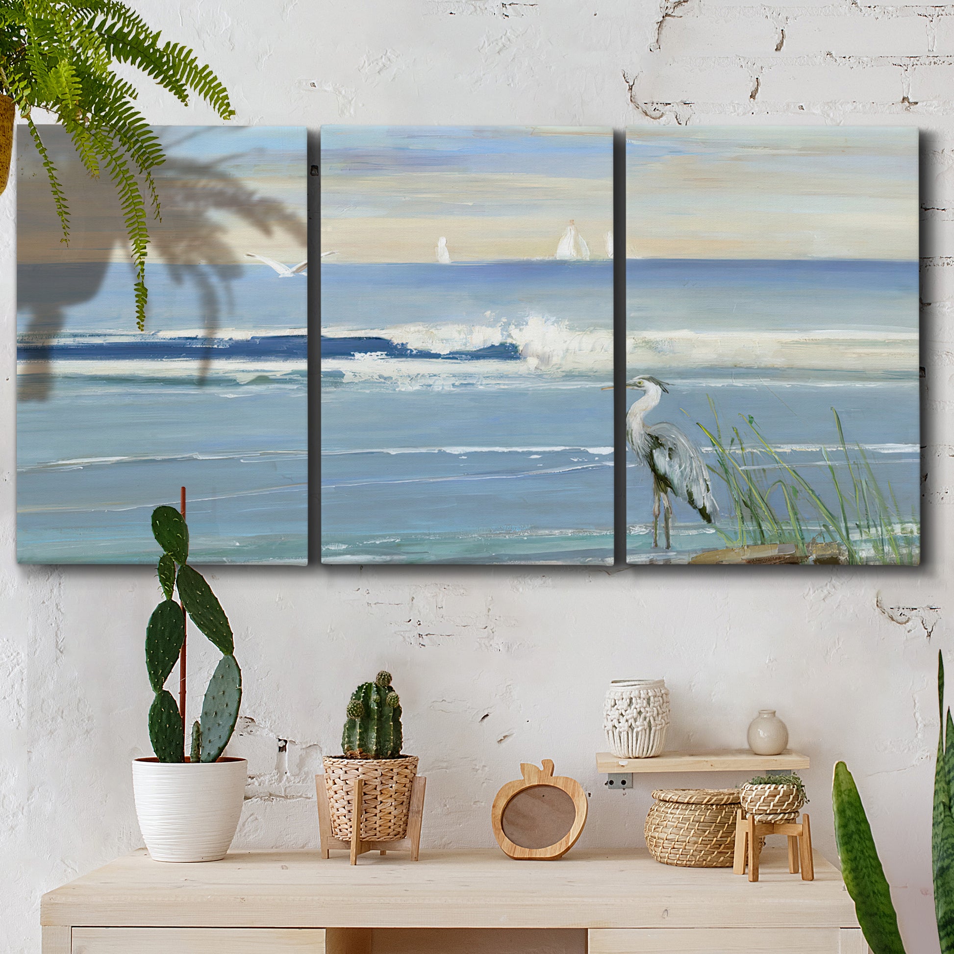 Three-panel canvas wall art featuring sunrise reflecting across bay waters, displayed in a boho-chic entryway above a console table.