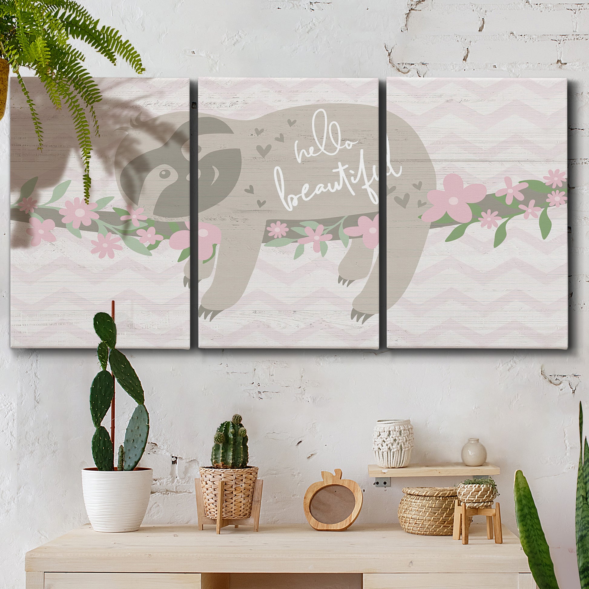 Three-panel canvas wall art featuring sloth with floral decorative elements, displayed in a boho-chic entryway above a console table.