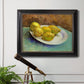 Impressionist still life with lemons by Vincent van Gogh in an ornate black frame with gilded inner detail displayed in a light-toned interior setting.