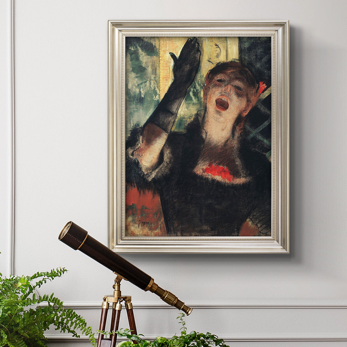Impressionist portrait of a café singer by Edgar Degas in an ornate champagne frame displayed in a light-toned interior setting.