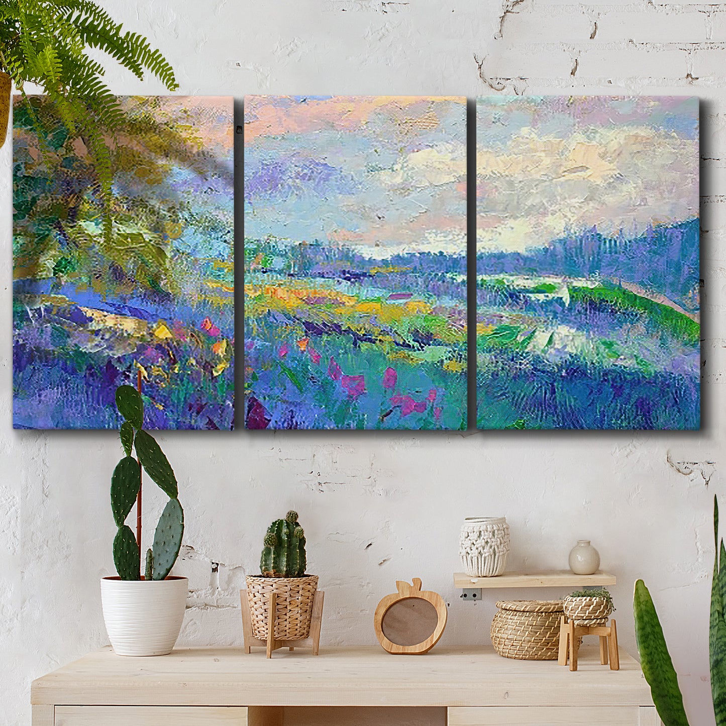 Three-panel canvas wall art featuring cheerful landscape under open sky, displayed in a boho-chic entryway above a console table.