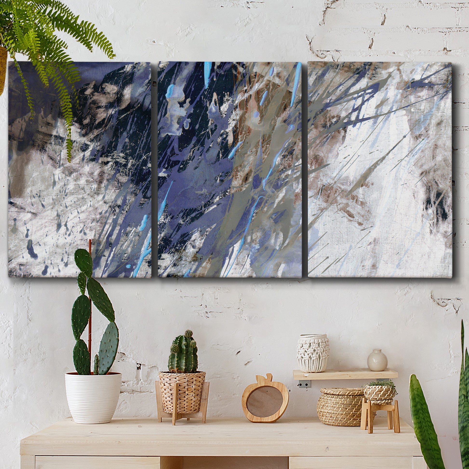 Three-panel canvas wall art featuring textured blue abstract composition, displayed in a boho-chic entryway above a console table.