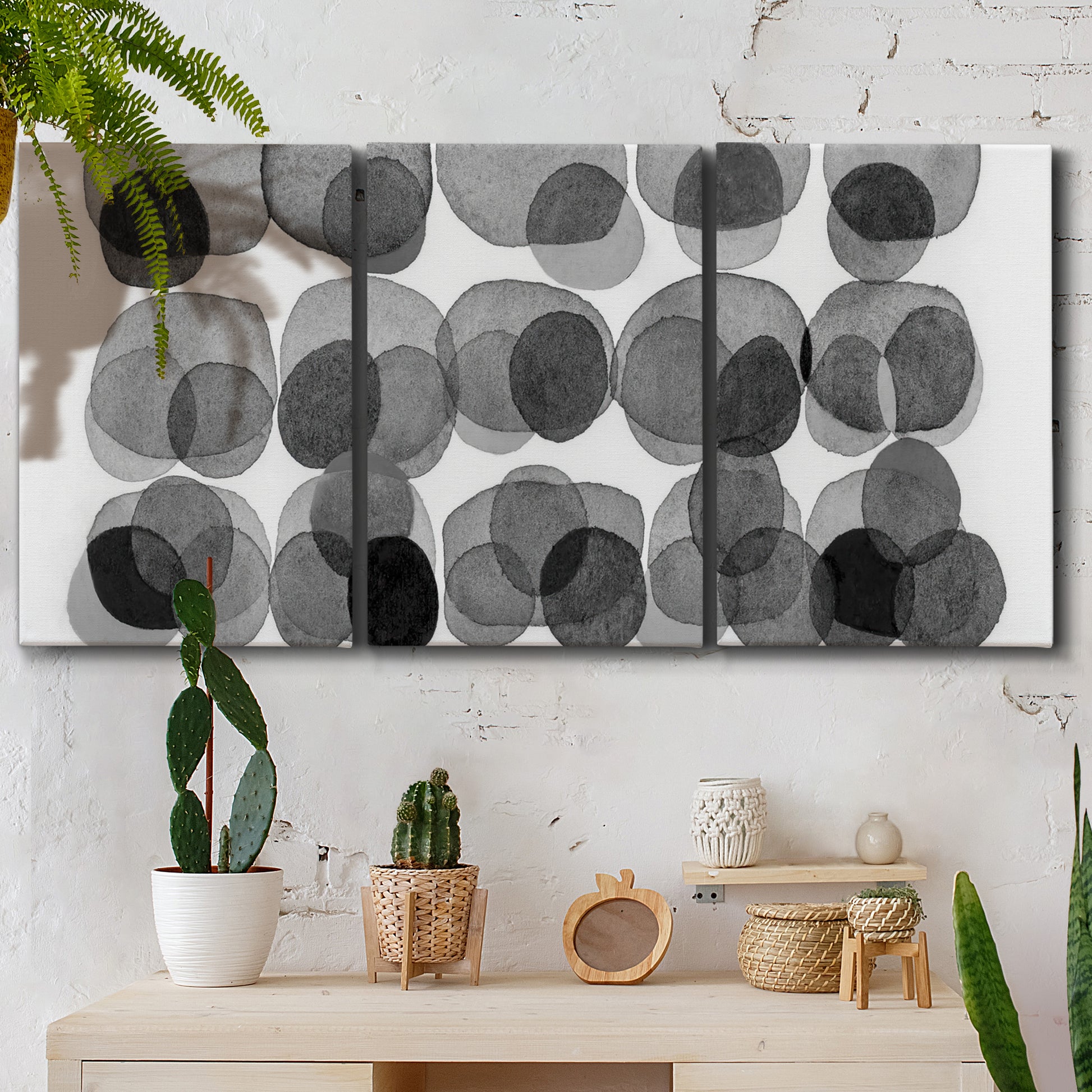 Three-panel canvas wall art featuring geometric abstract watercolor forms, displayed in a boho-chic entryway above a console table.