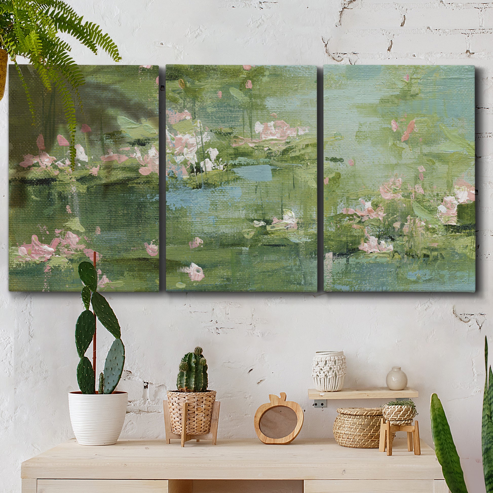 Three-panel canvas wall art featuring soft green water lilies, displayed in a boho-chic entryway above a console table.