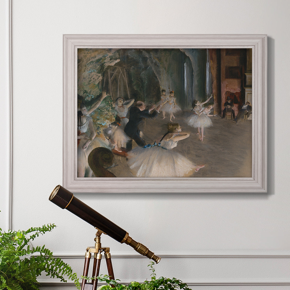 Impressionist backstage ballet scene by Edgar Degas in an ornate weathered white frame displayed in a light-toned interior setting.