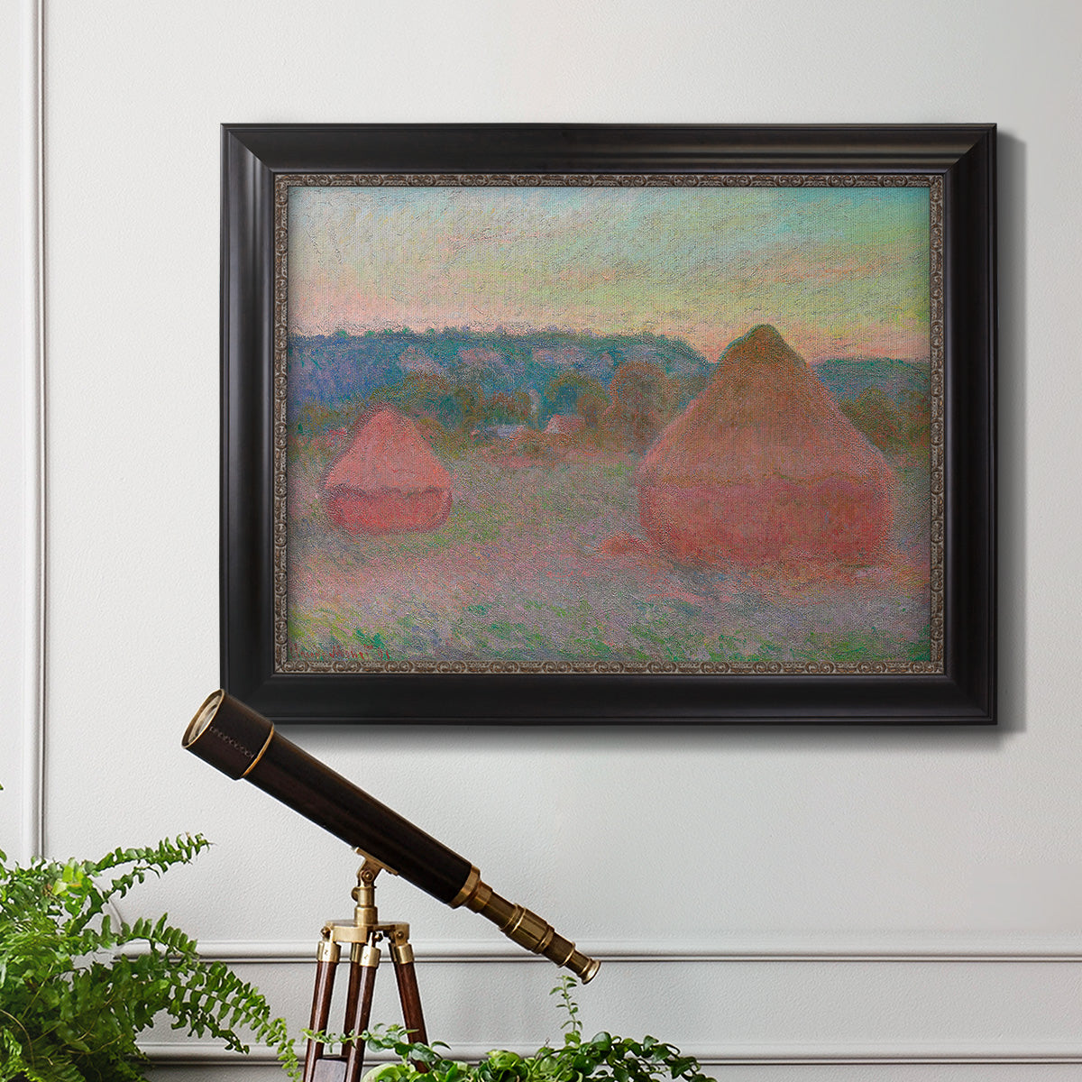 Impressionist haystack series landscape by Claude Monet in an ornate black frame with gilded inner detail displayed in a light-toned interior setting.