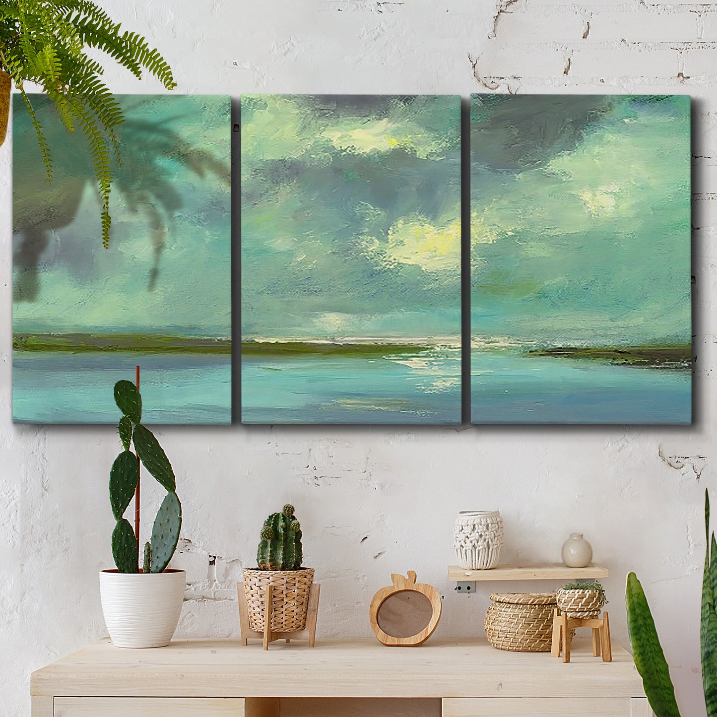 Three-panel canvas wall art featuring still lagoon water beneath open sky, displayed in a boho-chic entryway above a console table.
