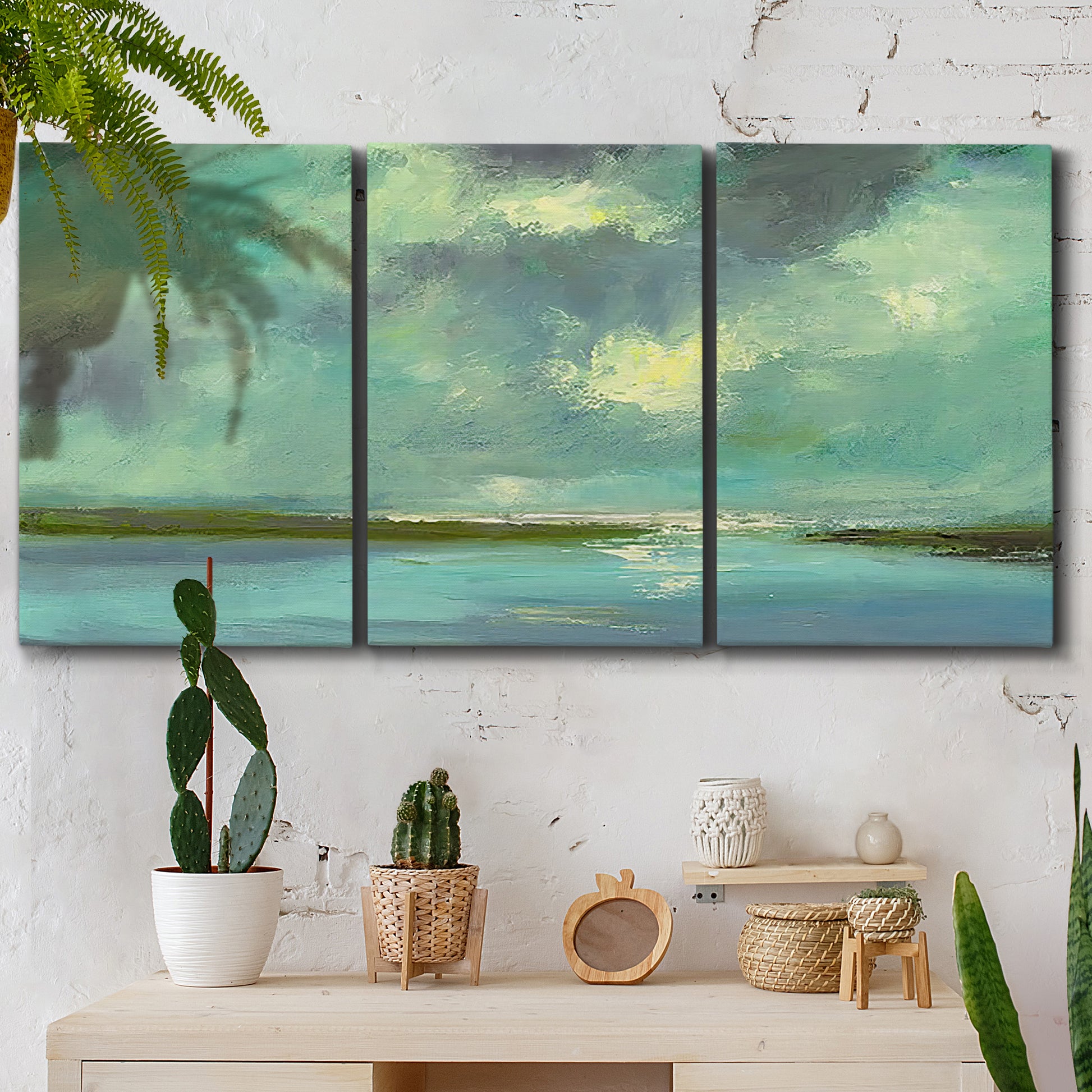 Three-panel canvas wall art featuring still lagoon water beneath open sky, displayed in a boho-chic entryway above a console table.