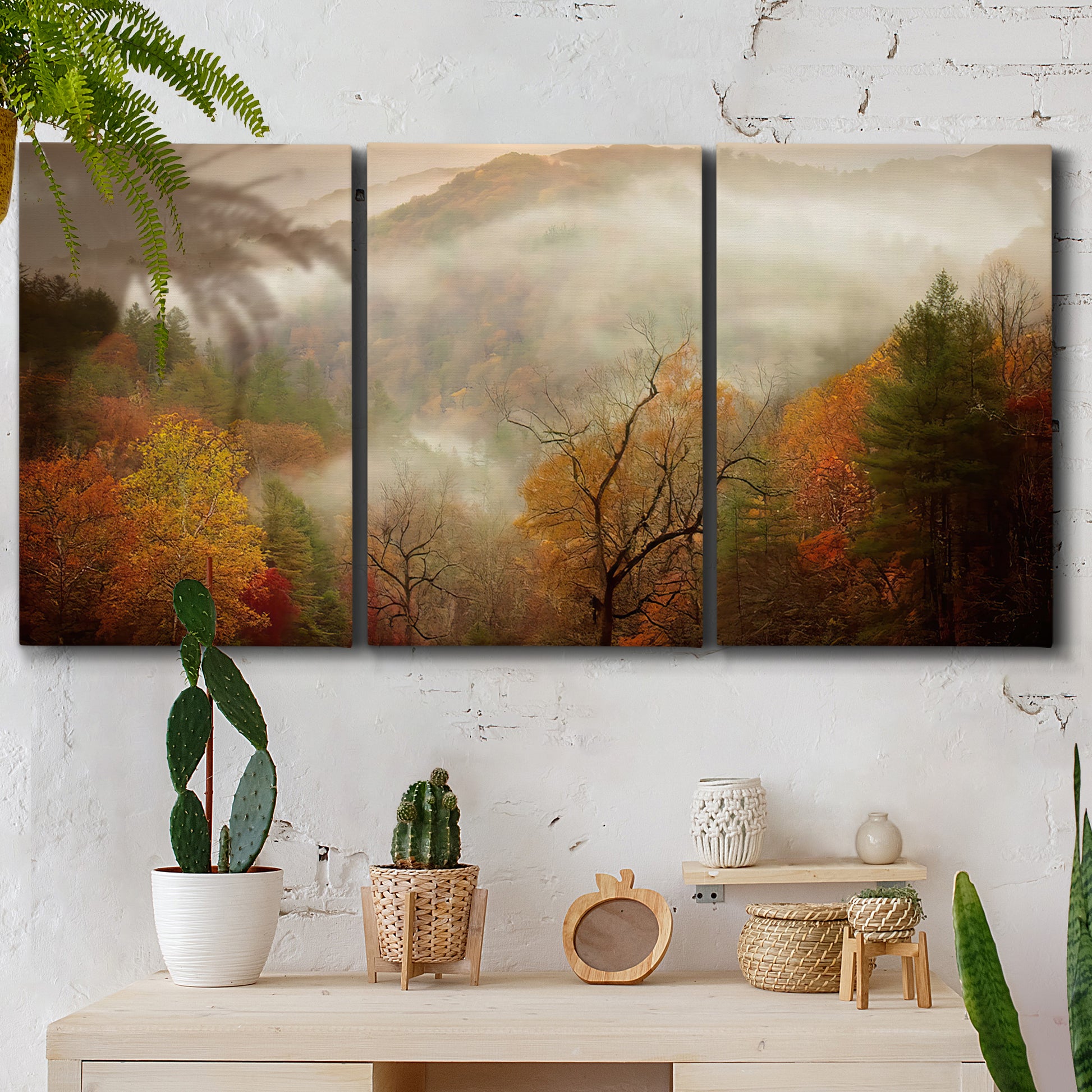 Three-panel canvas wall art featuring misty autumn landscape photograph, displayed in a boho-chic entryway above a console table.