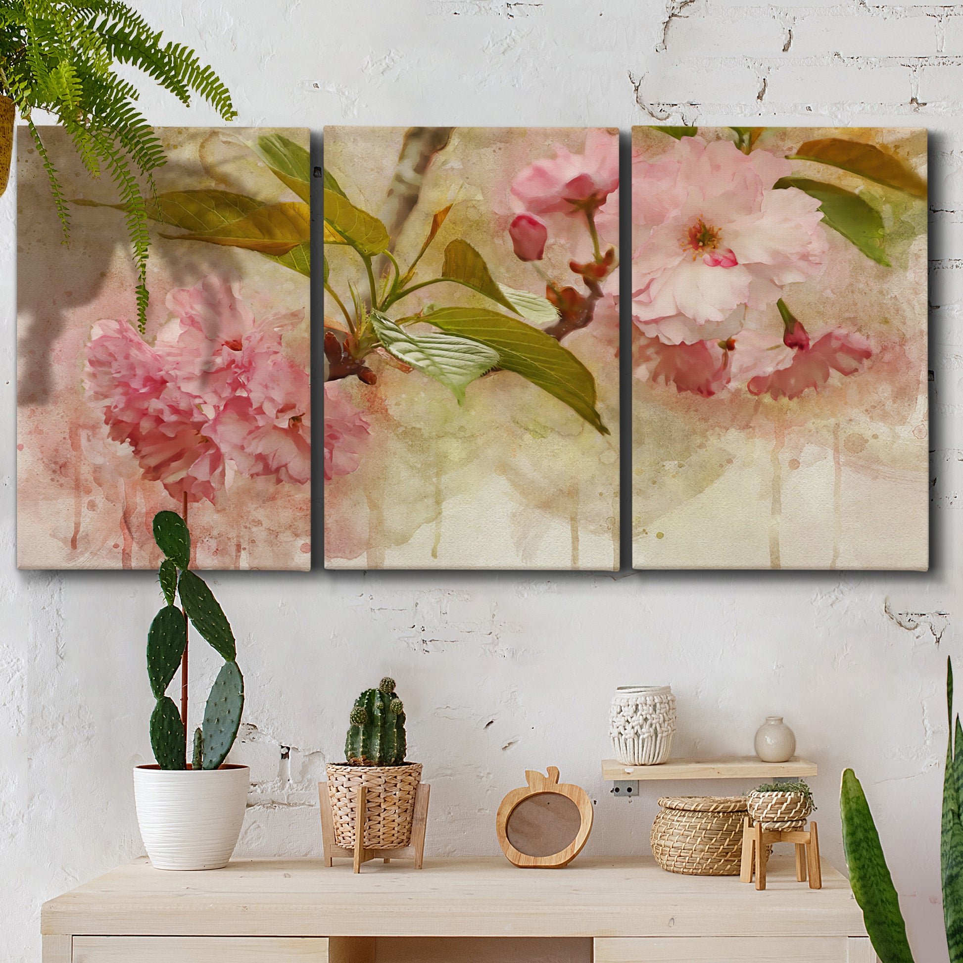 Three-panel canvas wall art featuring soft floral blossom composition, displayed in a boho-chic entryway above a console table.