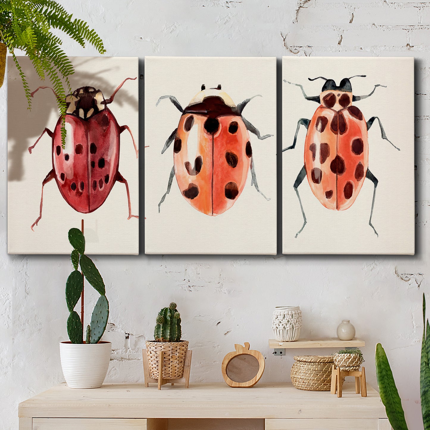 Three-panel canvas wall art featuring ladybugs on green foliage, displayed in a boho-chic entryway above a console table.