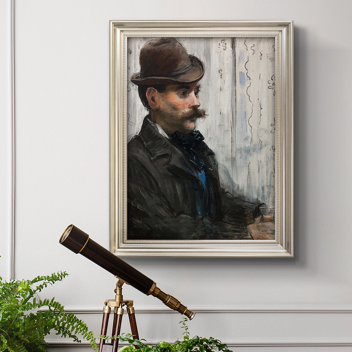 Impressionist portrait of a seated man by Édouard Manet in an ornate champagne frame displayed in a light-toned interior setting.