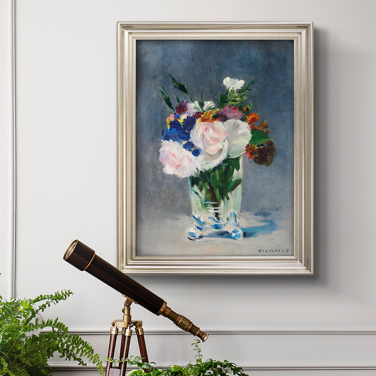 Impressionist floral still life painting by Claude Monet in an ornate champagne frame displayed in a light-toned interior setting.