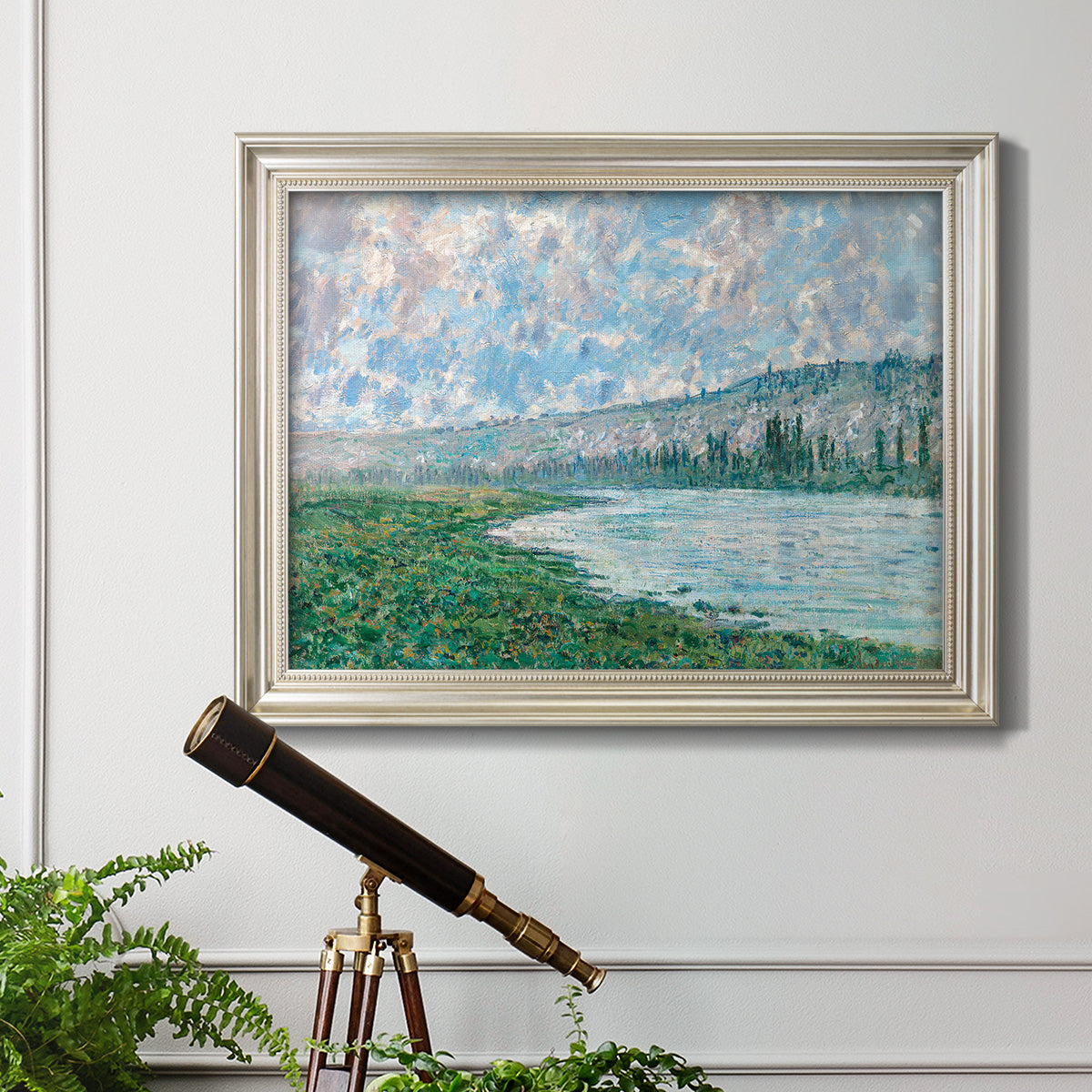 Impressionist river landscape at Vétheuil by Claude Monet in an ornate champagne frame displayed in a light-toned interior setting.