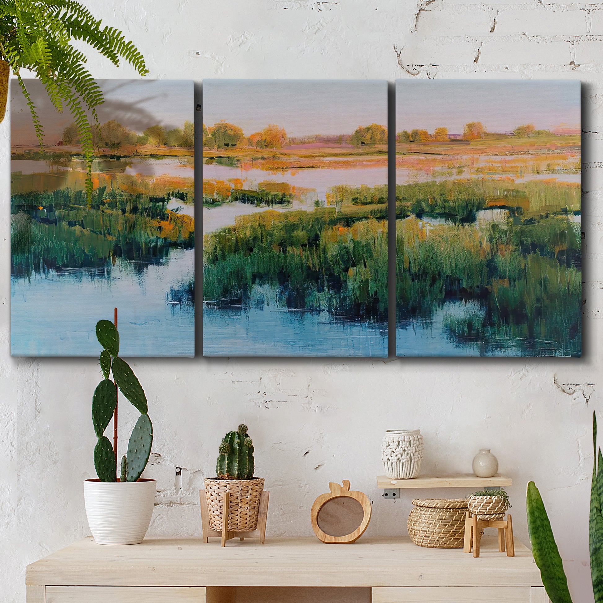 Three-panel canvas wall art featuring pastoral marshland landscape, displayed in a boho-chic entryway above a console table.