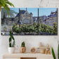 Three-panel canvas wall art featuring gothic church within city setting, displayed in a boho-chic entryway above a console table.