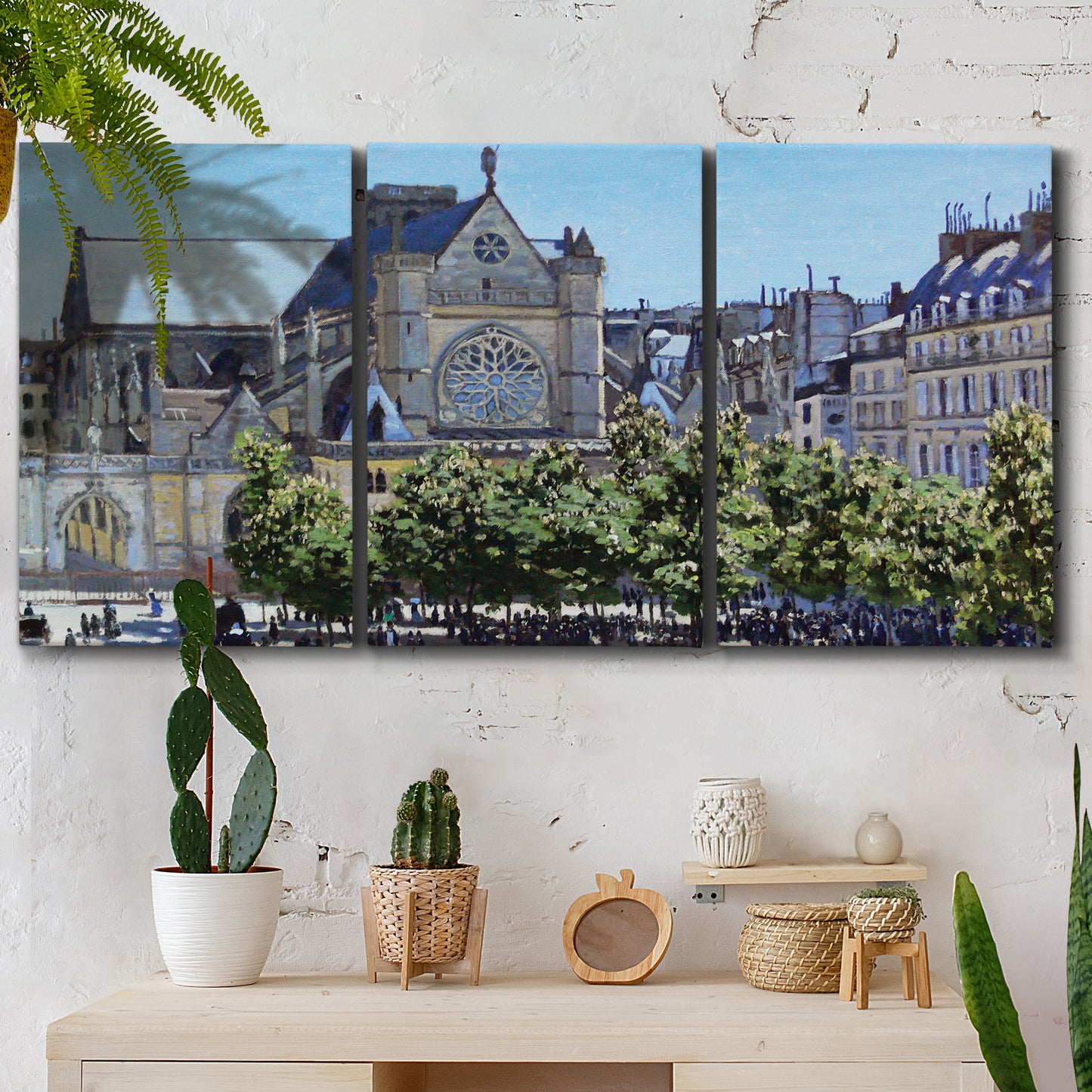 Three-panel canvas wall art featuring gothic church within city setting, displayed in a boho-chic entryway above a console table.